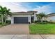 Single-story home with a gray garage door, and a manicured lawn at 17120 Cresswind Ter, Bradenton, FL 34211