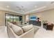 Living room with sectional sofa, large TV, and sliding glass doors leading outside at 17120 Cresswind Ter, Bradenton, FL 34211