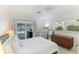 Main bedroom with pool view, mid century modern dresser, and white bedding at 181 Beeney Se Rd, Port Charlotte, FL 33952