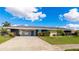 Mid-century modern home with carport and landscaped yard at 181 Beeney Se Rd, Port Charlotte, FL 33952