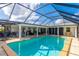 Large, screened-in pool with surrounding patio and seating at 181 Beeney Se Rd, Port Charlotte, FL 33952