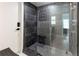 Walk in shower with dark tile and glass enclosure at 181 Beeney Se Rd, Port Charlotte, FL 33952