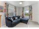 Small sitting area with L-shaped sofa and colorful mid-century modern curtains at 181 Beeney Se Rd, Port Charlotte, FL 33952