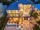 Night view of a two-story home with modern features and a metal roof at 1914 Riverside E Dr, Bradenton, FL 34208
