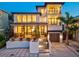 Two-story home with lighted porch and modern design, at night at 1914 Riverside E Dr, Bradenton, FL 34208