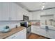Modern kitchen with white cabinets, wood countertops and a farmhouse sink at 2726 Jerry Ave, Punta Gorda, FL 33950