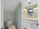 Small bathroom with toilet and a vanity with a round mirror at 315 Hammock Cir, Anna Maria, FL 34216