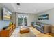 Bright living room with hardwood floors, comfortable sofa, and access to a balcony at 315 Hammock Cir, Anna Maria, FL 34216