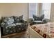 Bedroom with floral sofa and chair, plus a view of the backyard at 322 Blackburn Blvd, North Port, FL 34287