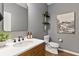Stylish powder room with wood vanity and gray walls at 3409 Anchor Bay Trl, Lakewood Ranch, FL 34211