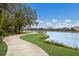 Curving concrete path winds beside a lake with a dock, offering scenic community views at 3409 Anchor Bay Trl, Lakewood Ranch, FL 34211