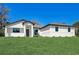 Single-story home with white exterior, dark trim, and grassy lawn at 3850 Skyway Ave, North Port, FL 34288