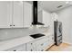 Modern kitchen with white cabinets, black range hood, and stainless steel appliances at 3850 Skyway Ave, North Port, FL 34288