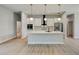 Open kitchen with white cabinets, island, and light wood floors at 3850 Skyway Ave, North Port, FL 34288