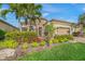 Landscaped front yard with palm trees and brick paver driveway at 3904 Waypoint Ave, Osprey, FL 34229