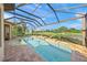 Enclosed pool area with spa and golf course view at 3904 Waypoint Ave, Osprey, FL 34229