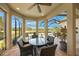 Screened sunroom with glass table and wicker chairs overlooking the pool at 3904 Waypoint Ave, Osprey, FL 34229