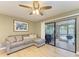 Bright living room with grey sectional sofa, sliding glass doors to patio, and ceiling fan at 4918 25Th W St # 102, Bradenton, FL 34207