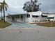 Front view of a white manufactured home with a carport at 5013 Oakland Hills Ave, Sarasota, FL 34234