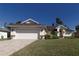 House exterior view, featuring a white double garage door and manicured lawn at 5107 86Th Street W Ct, Bradenton, FL 34210