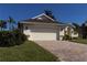 House exterior featuring a two-car garage and manicured landscaping at 5107 86Th Street W Ct, Bradenton, FL 34210