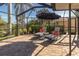 Spacious screened-in patio with lounge chairs and a blue umbrella at 5107 86Th Street W Ct, Bradenton, FL 34210