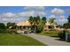 Community clubhouse with palm trees and golf carts at 5240 Hyland Hills Ave # 1411, Sarasota, FL 34241