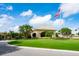 Community clubhouse with welcoming entryway, flag, and lush landscaping at 5240 Hyland Hills Ave # 1411, Sarasota, FL 34241