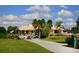 Community building exterior with palm trees and golf carts at 5240 Hyland Hills Ave # 1411, Sarasota, FL 34241