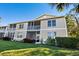 Two-story building exterior, screened balconies, lush landscaping at 5240 Hyland Hills Ave # 1411, Sarasota, FL 34241