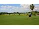 Putting green on a sunny day with golfers at 5240 Hyland Hills Ave # 1411, Sarasota, FL 34241