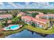 Aerial view showcasing community buildings and a tranquil pond at 5700 Bentgrass Dr # 16-211, Sarasota, FL 34235