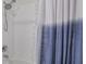 Clean bathroom with a shower/tub combo and blue curtain at 5700 Bentgrass Dr # 16-211, Sarasota, FL 34235