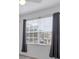 Bright bedroom with large window and gray curtains at 5700 Bentgrass Dr # 16-211, Sarasota, FL 34235