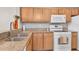 Kitchen features wood cabinets, granite counters & white appliances at 5700 Bentgrass Dr # 16-211, Sarasota, FL 34235