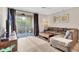 Living room with L-shaped sofa and balcony access at 5700 Bentgrass Dr # 16-211, Sarasota, FL 34235