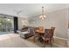 Living room with L-shaped sofa, balcony access, and TV at 5700 Bentgrass Dr # 16-211, Sarasota, FL 34235