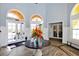 Bright and airy lobby with a large circular table and fresh flowers at 5700 Bentgrass Dr # 16-211, Sarasota, FL 34235