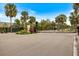 Gated entrance to community with palm trees and landscaping at 6077 Amberly Dr, Bradenton, FL 34208
