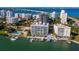 Aerial view of waterfront community with pool, boat slips, and city skyline at 650 Golden Gate Pt # 401, Sarasota, FL 34236
