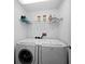 Laundry room with side-by-side washer and dryer and shelving at 650 Golden Gate Pt # 401, Sarasota, FL 34236
