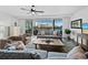 Spacious living room with water views, comfy seating, and hardwood floors at 650 Golden Gate Pt # 401, Sarasota, FL 34236