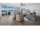 Spacious living room with water views, comfy seating, and hardwood floors at 650 Golden Gate Pt # 401, Sarasota, FL 34236
