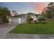 Beautiful home with lush landscaping, large lawn, and a paved driveway at 6702 Pinehurst Pl, Bradenton, FL 34202