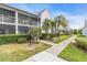 Condo building with walkway, landscaping, and palm trees at 6807 Stone River Rd # 204, Bradenton, FL 34203