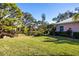 Landscaped backyard with grassy area and wooden bridge at 7213 Las Casas Dr, Sarasota, FL 34243
