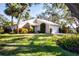 Light pink house with a white garage door and lush green lawn at 7213 Las Casas Dr, Sarasota, FL 34243