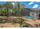 Large backyard with a screened pool and lush landscaping at 7408 Oak Run Ln, Sarasota, FL 34243
