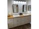Bathroom with double vanity, wood countertop, and large mirrors at 7408 Oak Run Ln, Sarasota, FL 34243