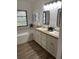 Bathroom with double vanity, wood countertop, and bathtub at 7408 Oak Run Ln, Sarasota, FL 34243